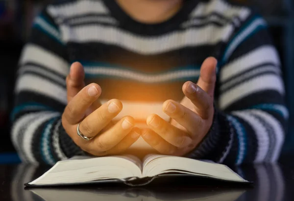 Christian hands while praying and worship for Jesus. christian people praying while hands worship over a Bible. learning religion. Selective focus on hands.