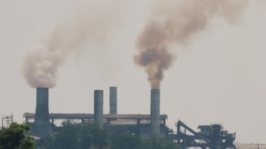 Enerji santrali gökyüzünü dolduran duman yığınından buhar salıyor. Fabrikadan baca tüttürüyorum. Sunrise çevre kirliliğinde enerji santrali ya da petrol rafinerisi bacaları. Hava kirliliği kavramı. Kamera B kaydı