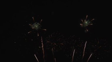 Real Fireworks 'ün gece arkaplanındaki ikinci çekimi. Gece gökyüzünde Bokeh ışıkları olan soyut, gerçek havai fişekler. Havai fişek festivali ve yılbaşı arifesi kutlaması. Renkli havai fişekler.