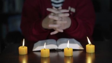 UHD 4k Ağır çekim, dua ederken ve İsa 'ya taparken genç Hıristiyan' ın B rulosu. Elleri İncil 'in üzerinde ibadet ederken Hıristiyan insanlar dua ediyor. Dini öğrenmek. Tanrı 'ya tapmak. Düşük ışık atışı.