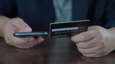 Online banking with smart phone for shopping. Hands holding a credit card while pressing number id on mobile from credit card for shopping online. Easy pay using mobile. Footage B roll slow motion 4k.