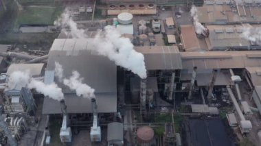 Zehirli bacaların etrafında uçan dron görüntüsü. Hava kirleticileri, yoğun duman ve yanan fosil yakıtlarla sanayi bölgesi. Endüstriyel fabrikada sera gazı emisyonu. B sahnesi 4k