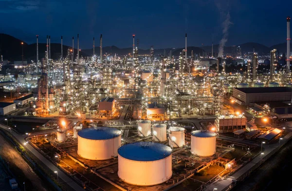 Aerial view drone of oil storage tank with oil refinery factory industrial. Oil refinery plant at beautiful sky sunset and twilight. industry factory concept and transportation.