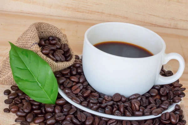 Закрыть чашку кофе и кофейных зерен — стоковое фото
