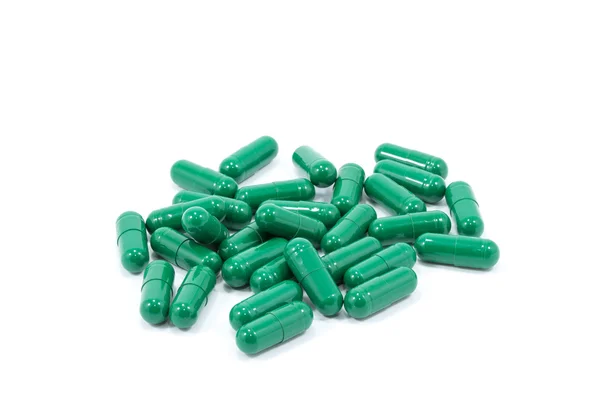 Green capsule pills on white background — Stok fotoğraf