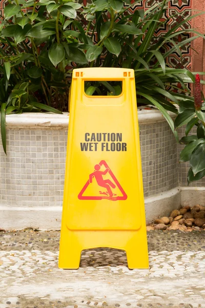 Znak Uwaga mokrej podłodze w ogrodzie — Zdjęcie stockowe