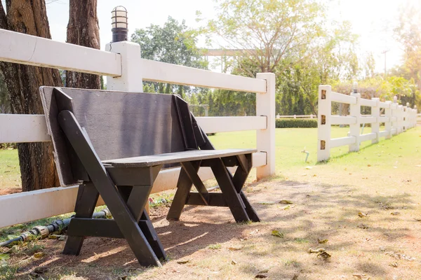 Vecchia panca in legno nel parco con luce solare — Foto Stock