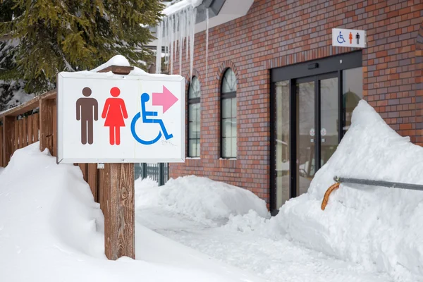 Restroom sign in the snow, show the way — Stock Photo, Image