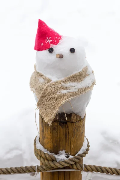 Little snowman on wooden pole — Stock Photo, Image