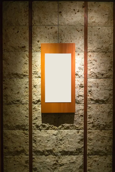 Blank wooden frame on stone wall illuminated spotlights in inter — Stock Photo, Image