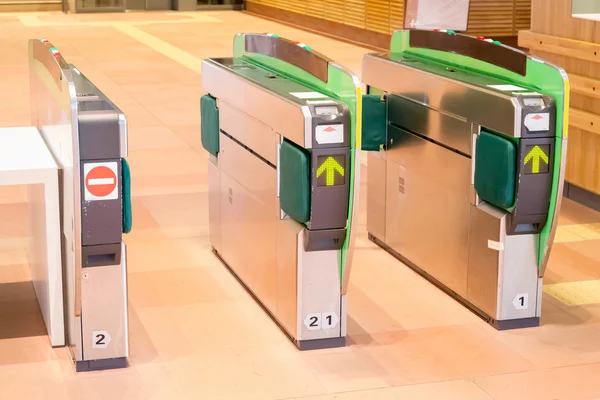 Turnstiles in underground railway station. Green arrows pointing — Stock Photo, Image