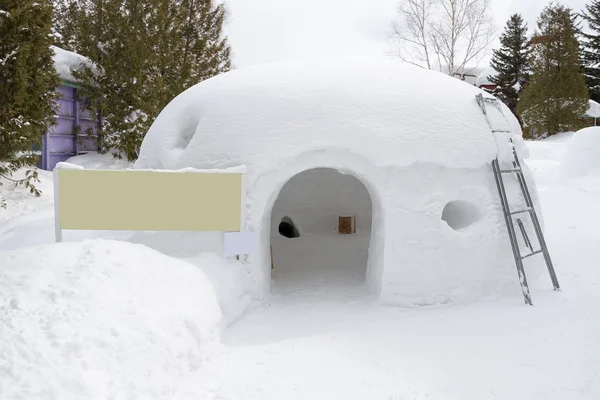 Snow shelter with blank yellow sign, for text or picture — Stock Photo, Image