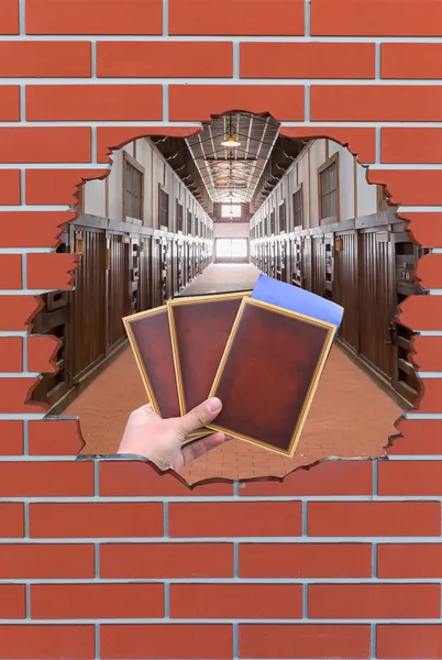 Brick hole with books or passports and jail scene — Stock Photo, Image