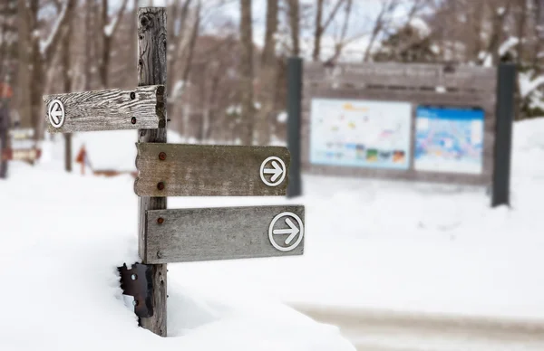 Wooden direction sign on the snow — Stock Photo, Image
