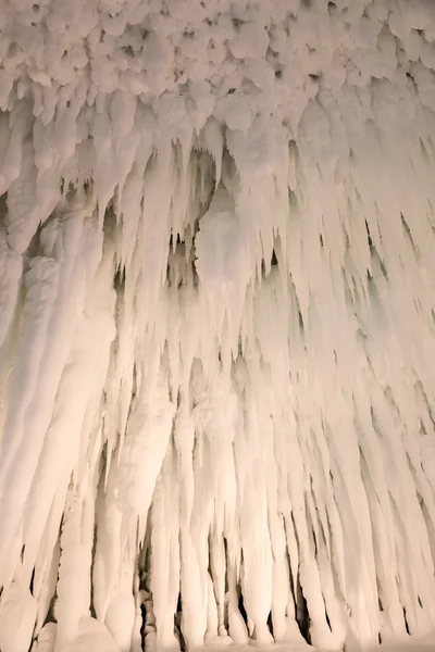 Hielo y carámbanos formando una estructura similar a una cueva bellamente illumi — Foto de Stock