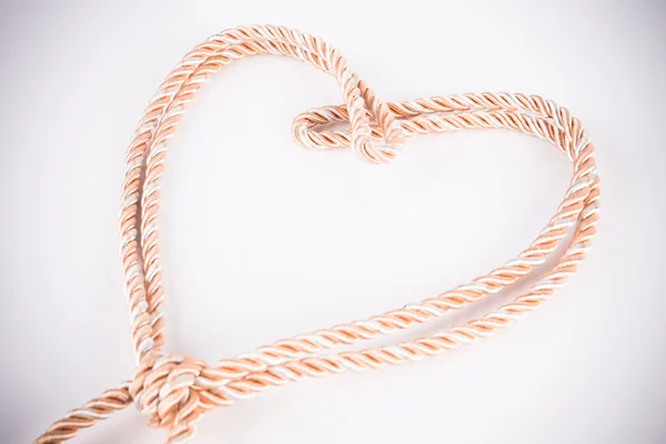 Orange rope in heart shape with vignette — Stock Photo, Image