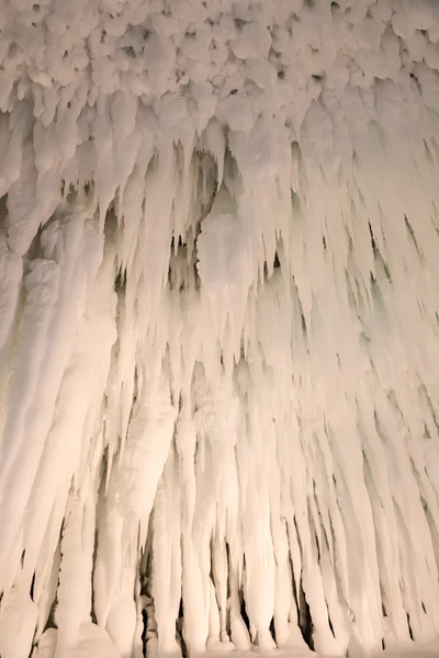 Eis und Eiszapfen bilden eine höhlenartige Struktur, die wunderschön illumi Stockbild