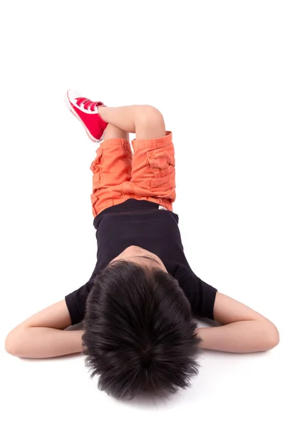 Netter Junge auf dem Boden liegend, isoliert auf weiß — Stockfoto