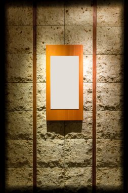 Blank wooden frame on stone wall illuminated spotlights in inter clipart