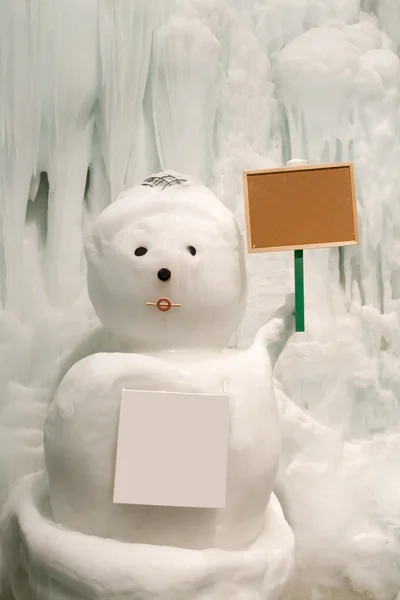 Muñeco de nieve con signo en blanco en la parte delantera —  Fotos de Stock