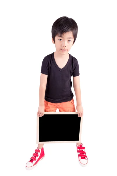 Leende pojke innehar en svart tavla över vit bakgrund — Stockfoto