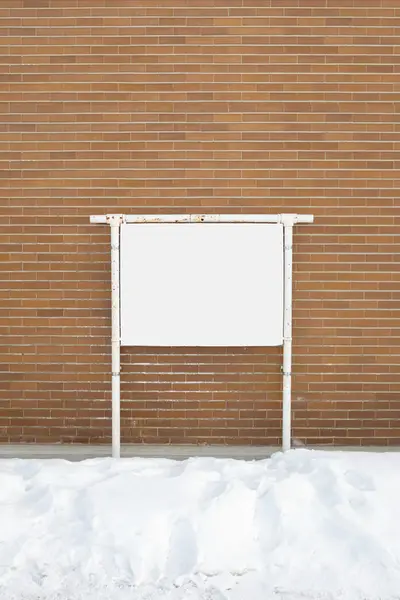 Um cartaz em branco anexado a uma parede de tijolo exterior de edifícios — Fotografia de Stock