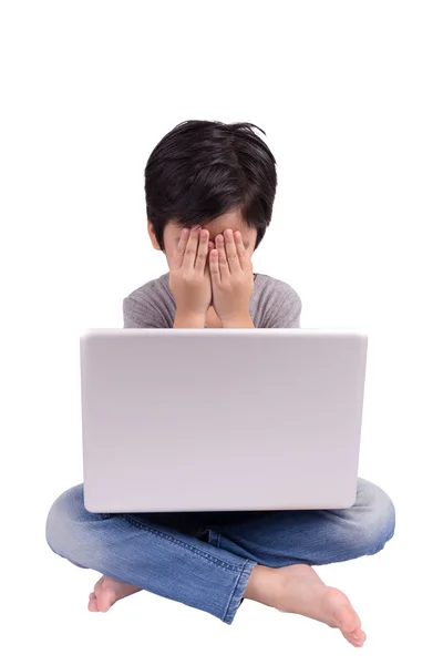 Little boy in front of laptop hiding his face — Stock Photo, Image