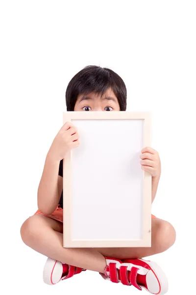 Menino bonito está olhando para fora do banner em branco, isolado sobre whi — Fotografia de Stock