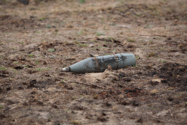 An unexploded artillery shell on the ground