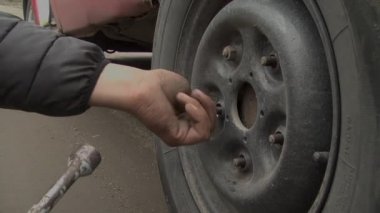Unscrewing nuts to replace a car wheel