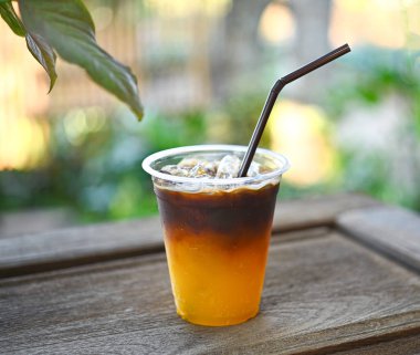 Portakal suyuyla karıştırılmış bir bardak buzlu kahve. Lezzetli görünüyor, taze kokuyor. Bahçede meyve suyu ile karıştırılmış kahveyi tazeliyorum. Doğal olarak dinlenme zamanı..