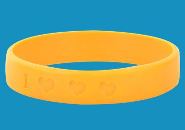 Parlak sarı silikon bileklik ve mavi arka planda kalp şeklinde oyulmuş.