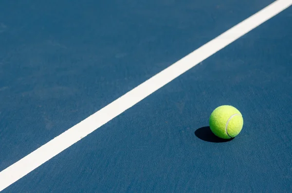 Tennis ball on a tennis court close to the line — Stock Photo, Image