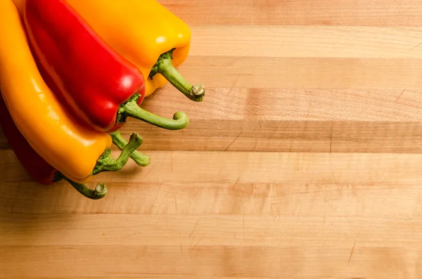 Fresh peppers on chopping board — Stock Photo, Image