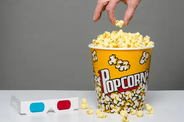 Hand greift nach Popcorn — Stockfoto