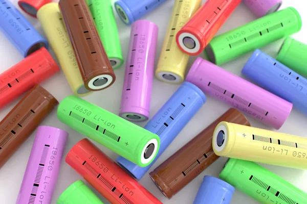 Lots of cylindrical 18650 lithium-ion batteries on a white table. Li-ion rechargeable batteries in various colors for electrical devices. Galvanic cells