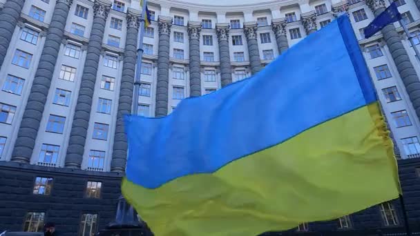 Національний прапор України на тлі урядового будинку в Києві. — стокове відео