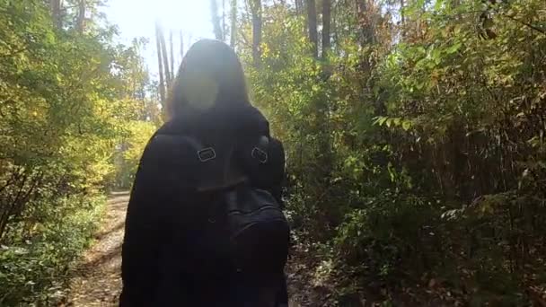 Дівчина проходить через осінній ліс — стокове відео