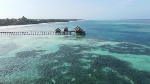Vista aérea de uma casa sobre palafitas no oceano na costa de Zanzibar, Tanzânia, câmera lenta — Vídeo de Stock