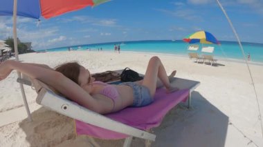 Kadın, Tanzanya, Zanzibar 'da Nungwi sahilinde güneşleniyor, ağır çekim.