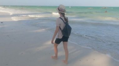 Zanzibar, Tanzanya 'da kumsalda yürüyen bir kadın, ağır çekim.