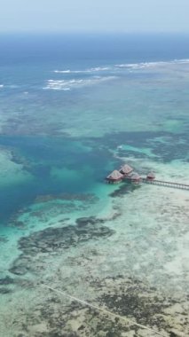 Tanzanya 'nın Zanzibar sahilinde, okyanustaki sazlıklar üzerinde dikey video evi
