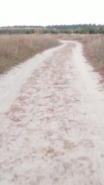Dikey video boş bir alanda toprak bir yol