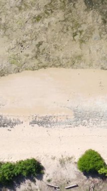 Tanzanya - Zanzibar kıyıları yakınlarındaki okyanusta alçak gelgitin dikey videosu, yavaş çekim