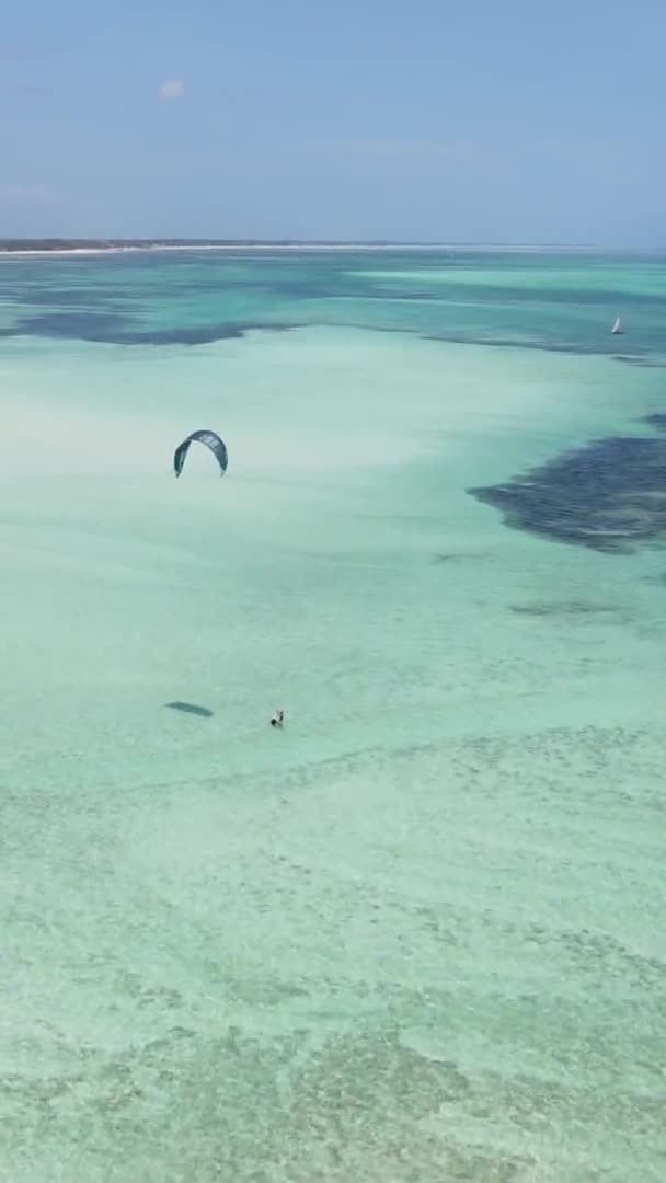タンザニアのザンジバル海岸近くの垂直ビデオカイトサーフィン、航空ビュー — ストック動画