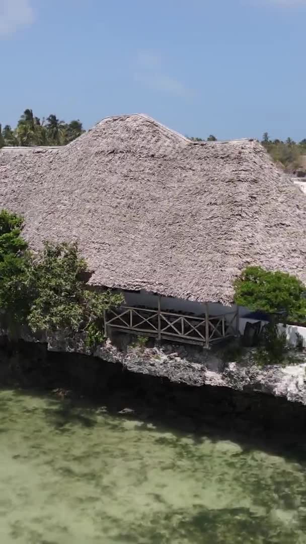 Maison vidéo verticale sur pilotis dans l'océan sur la côte de Zanzibar, Tanzanie, vue aérienne — Video