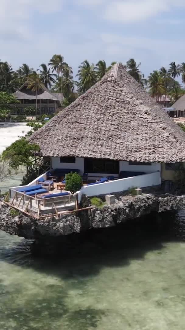 Verticale video huis op palen in de oceaan aan de kust van Zanzibar, Tanzania, luchtfoto — Stockvideo