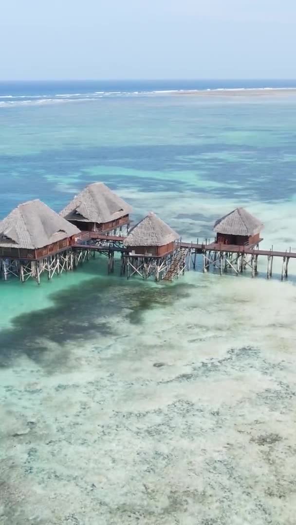 탄자니아 잔지바르 해안에 있는 해저 기둥들 위에 있는 수직 영상 집, 공중에서 본 광경 — 비디오