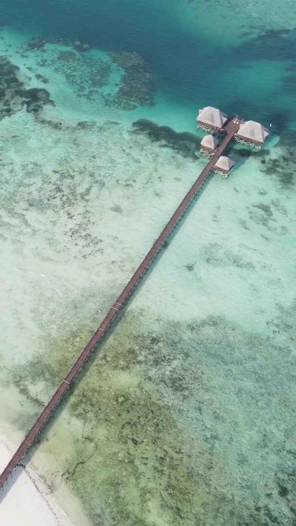 Maison vidéo verticale sur pilotis dans l'océan sur la côte de Zanzibar, Tanzanie, vue aérienne — Video