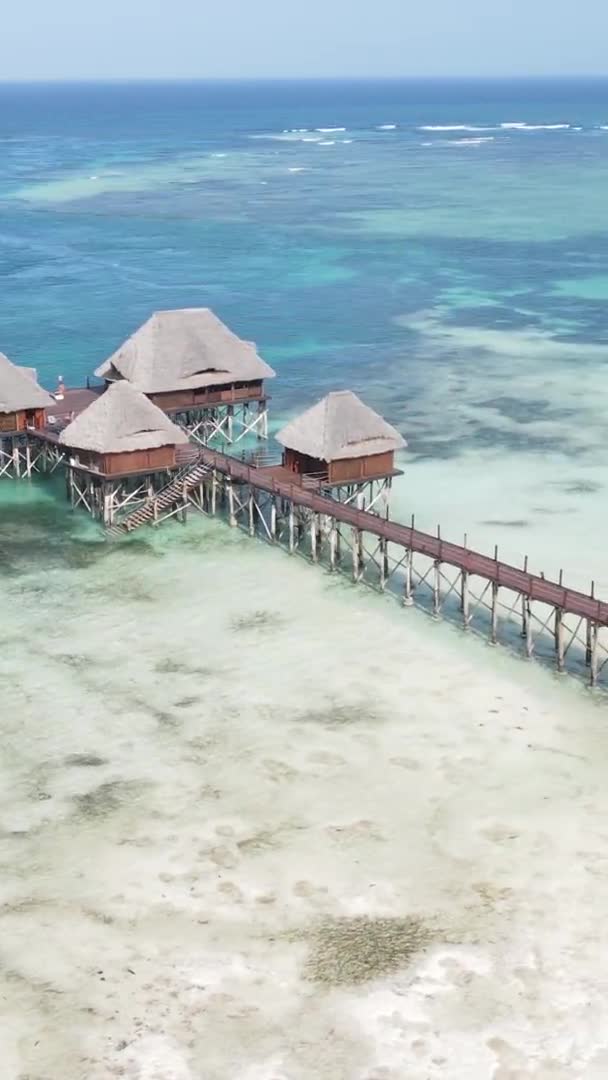Κάθετη σπίτι βίντεο σε ξυλοπόδαρα στον ωκεανό στις ακτές της Ζανζιβάρης, Τανζανία, εναέρια άποψη — Αρχείο Βίντεο